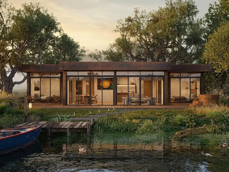 A long low glass-and-timber house at dusk beside a pond, with a timber dock and a moored rowing boat