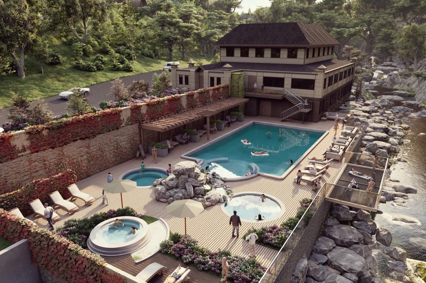 Aerial view of a hot-springs resort: a dark timber lodge, a long pool and circular soaking tubs set into stone terraces