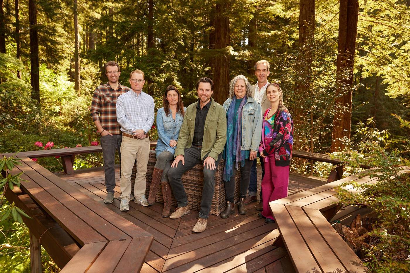 The Artistree Home team together on a curved redwood deck in the grove